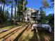 Home's backyard featuring mature trees, a dining table, and a screened porch at 6 Chelan Ct, Durham, NC 27713