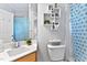 Cozy bathroom featuring white tiling and blue patterned shower curtain and neutral colors at 6 Chelan Ct, Durham, NC 27713