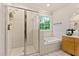 Bright bathroom featuring a shower, tub and window at 6 Chelan Ct, Durham, NC 27713