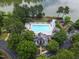 Aerial view of a community pool with playground surrounded by lush trees and a lake at 6 Chelan Ct, Durham, NC 27713