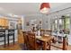 Open-concept dining area with hardwood floors, large windows, and an open view into the living room and kitchen at 6 Chelan Ct, Durham, NC 27713