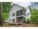 Two-story home exterior with a screened-in porch and patio, surrounded by lush greenery and trees at 6 Chelan Ct, Durham, NC 27713