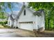 Angle showing side of the home with the attached garage, white siding, and well-maintained landscaping at 6 Chelan Ct, Durham, NC 27713