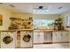 Practical kitchen and laundry area with updated appliances, butcher block counters, and ample shelving for storage at 6 Chelan Ct, Durham, NC 27713