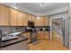 Modern kitchen features light wood cabinets, black countertops, stainless steel appliances, and hardwood flooring at 6 Chelan Ct, Durham, NC 27713