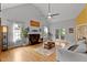 Bright living room features hardwood floors, a fireplace, a ceiling fan, and French doors to the backyard at 6 Chelan Ct, Durham, NC 27713