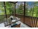 Outdoor screened porch featuring a dining table for outdoor meals and wooded scenery in the background at 6 Chelan Ct, Durham, NC 27713