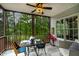 Inviting screened porch featuring a ceiling fan, marble table, and picturesque views of the surrounding trees at 6 Chelan Ct, Durham, NC 27713