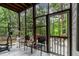 Relaxing screened porch featuring outdoor seating and exercise equipment, surrounded by lush greenery at 6 Chelan Ct, Durham, NC 27713