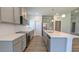 Open kitchen features gray cabinets, stainless appliances, a kitchen island and modern pendant lighting at 600 Sweet Potato Lane # 38, Nashville, NC 27856