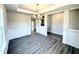 Open dining room featuring classic wainscoting, modern chandelier, and durable laminate flooring at 606 Melrose Ct, Sanford, NC 27330