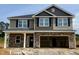 Two-story home featuring a stone facade, hardiplank siding, black shutters, and a two-car garage at 606 Melrose Ct, Sanford, NC 27330