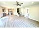 Open-concept living room showcasing laminate flooring, kitchen access, and staircase to upper level at 606 Melrose Ct, Sanford, NC 27330