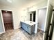 Bright main bathroom offers double sink vanity and tile flooring at 606 Melrose Ct, Sanford, NC 27330
