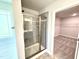 Walk-in shower with glass enclosure, gray tile, and access to walk-in closet at 606 Melrose Ct, Sanford, NC 27330