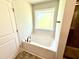 Bathroom features a soaking tub and window at 606 Melrose Ct, Sanford, NC 27330