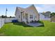 Backyard featuring a spacious, well-maintained lawn, a concrete patio with outdoor seating, and a privacy fence at 608 W Godwin St, Dunn, NC 28334