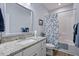 Bathroom with a granite-topped vanity, framed mirror, and a shower-tub combination with stylish curtain at 608 W Godwin St, Dunn, NC 28334
