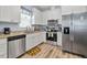 Bright kitchen features stainless steel appliances, white cabinets, granite counters, and wood-look flooring at 608 W Godwin St, Dunn, NC 28334