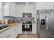 Bright kitchen features stainless steel appliances, white cabinets, granite counters, and wood-look flooring at 608 W Godwin St, Dunn, NC 28334