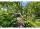 Expansive backyard with lush greenery, a pond feature, and a glimpse of the screened porch at 708 W Main St, Carrboro, NC 27510