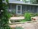 Charming backyard featuring a screened-in porch, lush foliage, and a small pond with stone trim at 708 W Main St, Carrboro, NC 27510