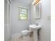 Bright bathroom with a pedestal sink, toilet, and window for natural light at 708 W Main St, Carrboro, NC 27510