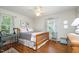 Comfortable bedroom with hardwood floors, abundant natural light, and ceiling fan at 708 W Main St, Carrboro, NC 27510