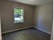 Comfortable bedroom with natural light from the window, featuring hardwood floors and neutral walls at 710 E Azalea Ct, Fuquay Varina, NC 27526