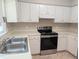 Well-lit kitchen with stainless steel appliances and white cabinets offers ample counter space at 710 E Azalea Ct, Fuquay Varina, NC 27526