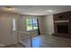 Inviting living room with hardwood floors, brick fireplace, and a window overlooking the landscaped front yard at 710 E Azalea Ct, Fuquay Varina, NC 27526