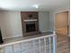 Spacious living room with hardwood floors, a brick fireplace, and an open doorway to another room at 710 E Azalea Ct, Fuquay Varina, NC 27526