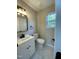 Updated bathroom with a modern vanity, sleek mirror, and marble-look tile floor at 717 Papsworth Ct, Fuquay Varina, NC 27526