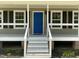 Close-up of a home's entrance with a bright blue door and white-railed porch at 717 Papsworth Ct, Fuquay Varina, NC 27526