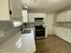 Modern kitchen features stainless steel appliances, light gray backsplash, and white cabinets at 717 Papsworth Ct, Fuquay Varina, NC 27526