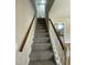 Carpeted stairway featuring a wood handrail at 717 Papsworth Ct, Fuquay Varina, NC 27526