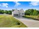 Inviting white two-story home featuring a gray garage door, landscaped yard, and long driveway at 72 Glenwood Pl, Kenly, NC 27542