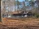 Inviting exterior of a single-story brick home with a swimming pool, shed, and wooded surroundings at 80 White Deer Ln, Henderson, NC 27537