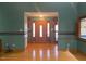 An open foyer leading to the front door, featuring hardwood floors and elegant wall decor at 80 White Deer Ln, Henderson, NC 27537