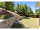 Well-kept backyard with retaining wall, lawn, and lush landscaping at 8840 Forester Ln, Apex, NC 27539
