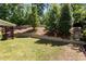 Picturesque backyard featuring a terraced retaining wall, a green lawn, and mature trees at 8840 Forester Ln, Apex, NC 27539
