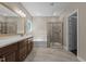 A luxurious bathroom featuring a soaking tub, glass shower, and elegant vanity with a large mirror at 8840 Forester Ln, Apex, NC 27539