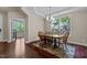 Cozy dining room with hardwood floors, a patterned rug, and large windows overlooking the yard at 8840 Forester Ln, Apex, NC 27539