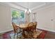 Bright dining room featuring hardwood floors, a stylish chandelier, and large windows at 8840 Forester Ln, Apex, NC 27539