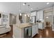 Open kitchen featuring island, stainless steel appliances, and hardwood floors connecting to the living area at 8840 Forester Ln, Apex, NC 27539