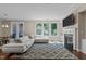 Open concept living room featuring hardwood floors, fireplace, and large windows at 8840 Forester Ln, Apex, NC 27539