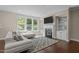 Inviting living room with large windows, a fireplace, custom built-ins, and a plush sectional sofa at 8840 Forester Ln, Apex, NC 27539