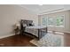 Serene main bedroom with tray ceiling, hardwood floors, and natural light from large windows at 8840 Forester Ln, Apex, NC 27539