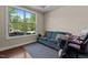 Bright office with hardwood floors, a comfortable sofa, and a large window showcasing outdoor views at 8840 Forester Ln, Apex, NC 27539