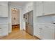 White kitchen with stainless steel appliances, ample cabinet space, and access to a mud room at 100 Highveld Ave, Chapel Hill, NC 27516